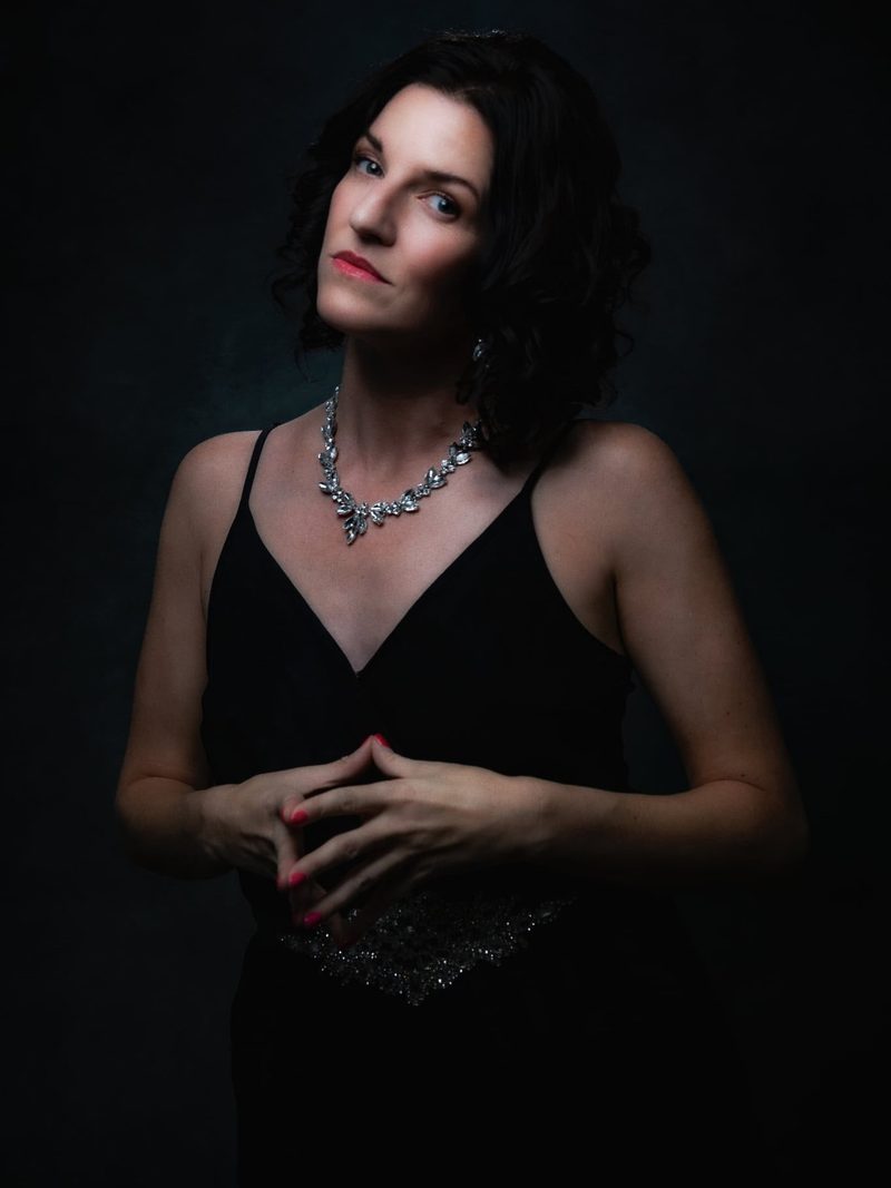 An elegant portrait of Keri in a black dress with a jeweled necklace.