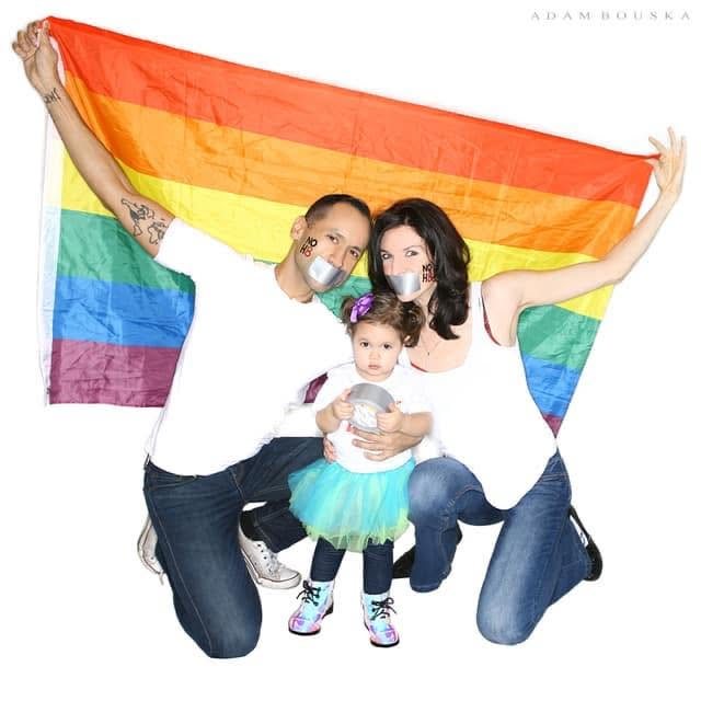 Keri and her family holding a rainbow flag for the NOH8 campaign.