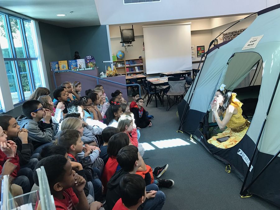 Keri in costume reading to children inside a Camp Read tent.