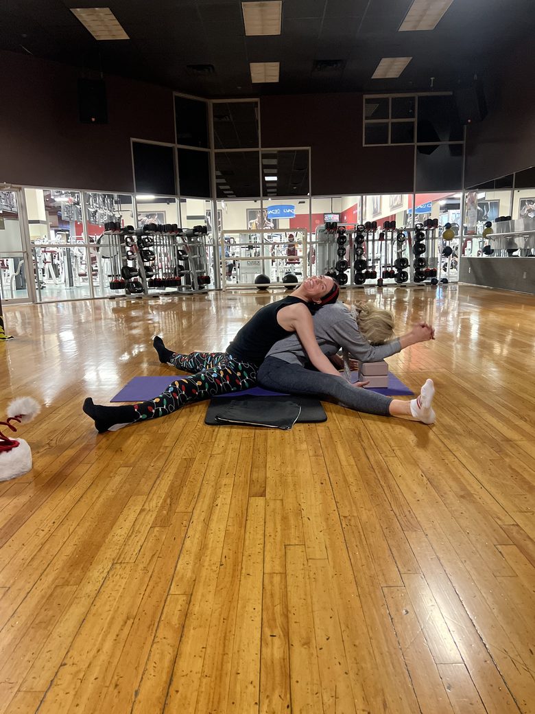 Keri laughing during a partner-yoga stretch.