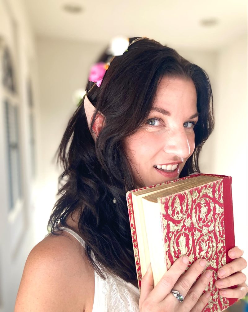 Keri wearing a flower crown and holding an ornate vintage storybook.
